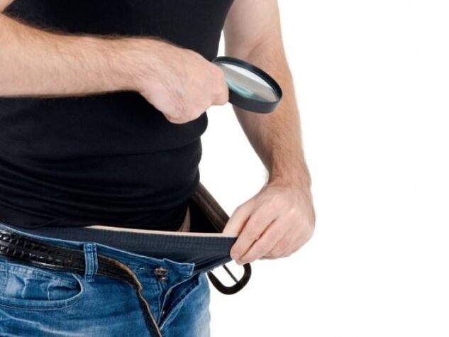 un hombre mira hacia abajo sus pantalones y quiere agrandar su pene